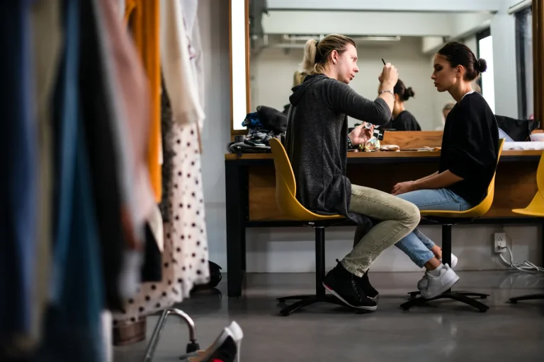 Two people facing each other in a rehearsal-room setting.
