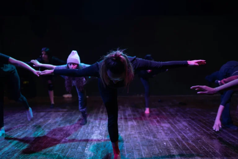 Dancers rehearsing in a studio/theatre.